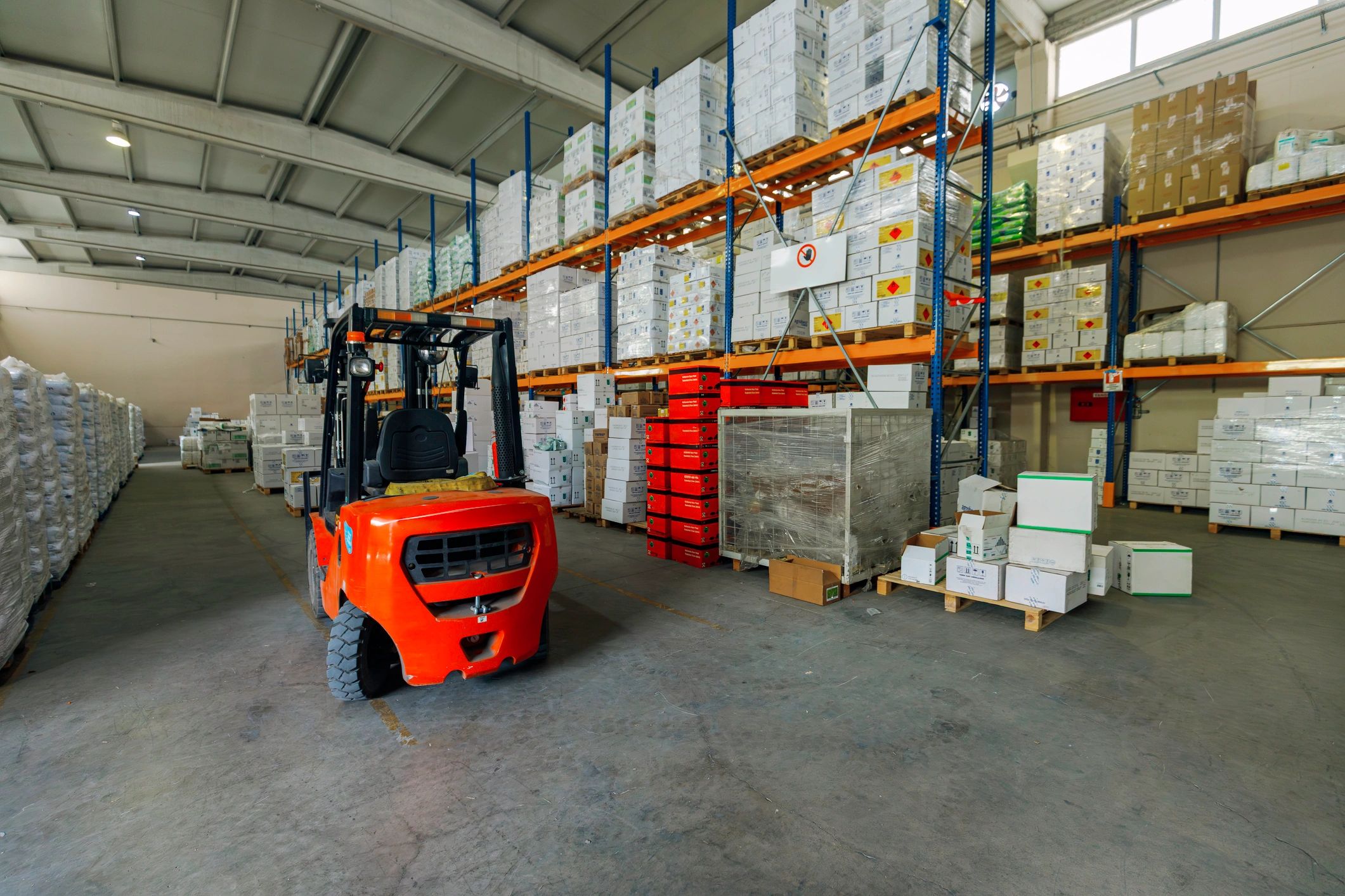 Warehouse aisle with forklift and palletised goods